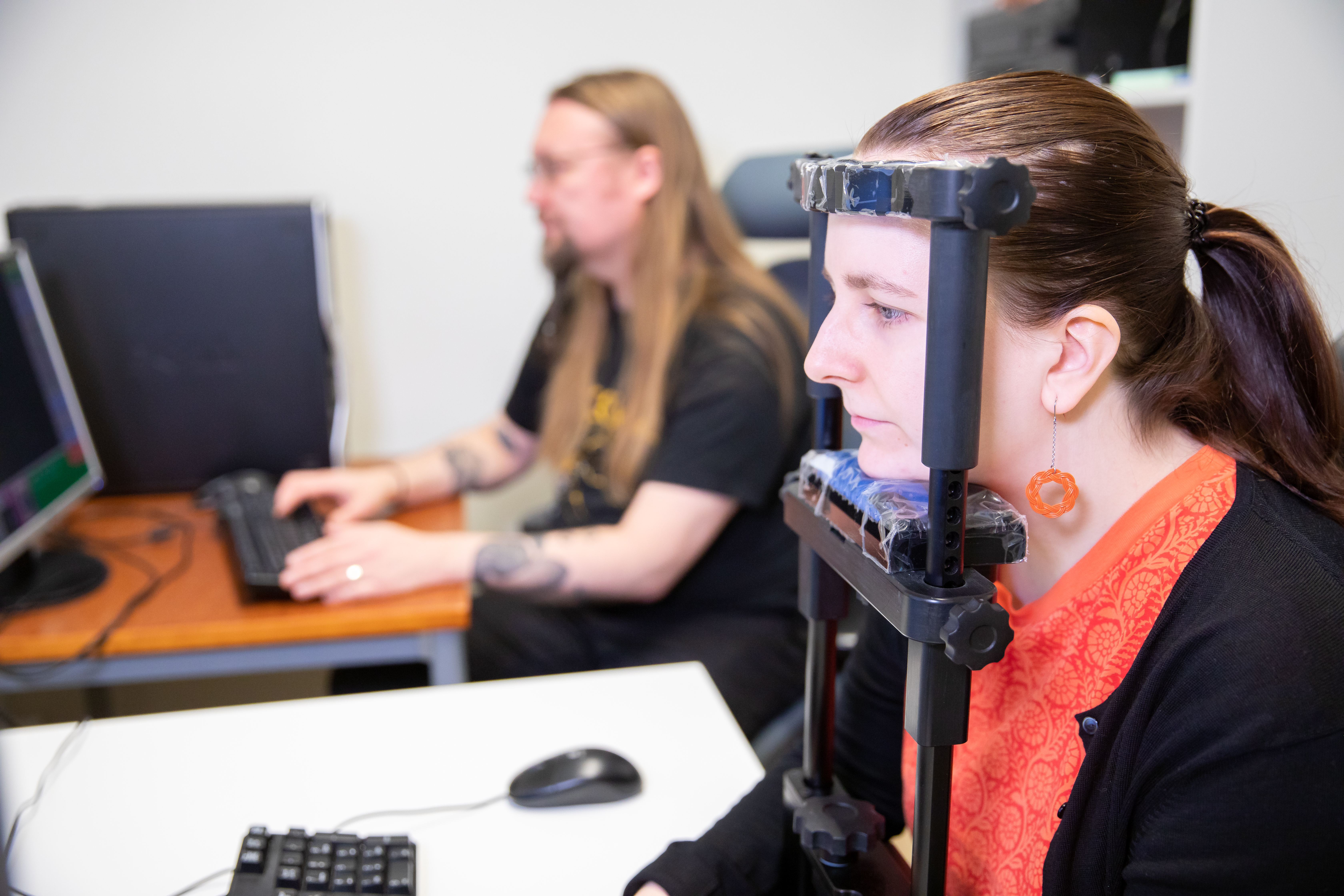 A participant in front of an eye tracker, researcher at the back.