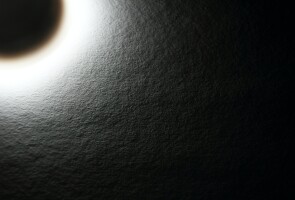 Auringonpimennystä muistuttava lampun kajo paperia vasten
