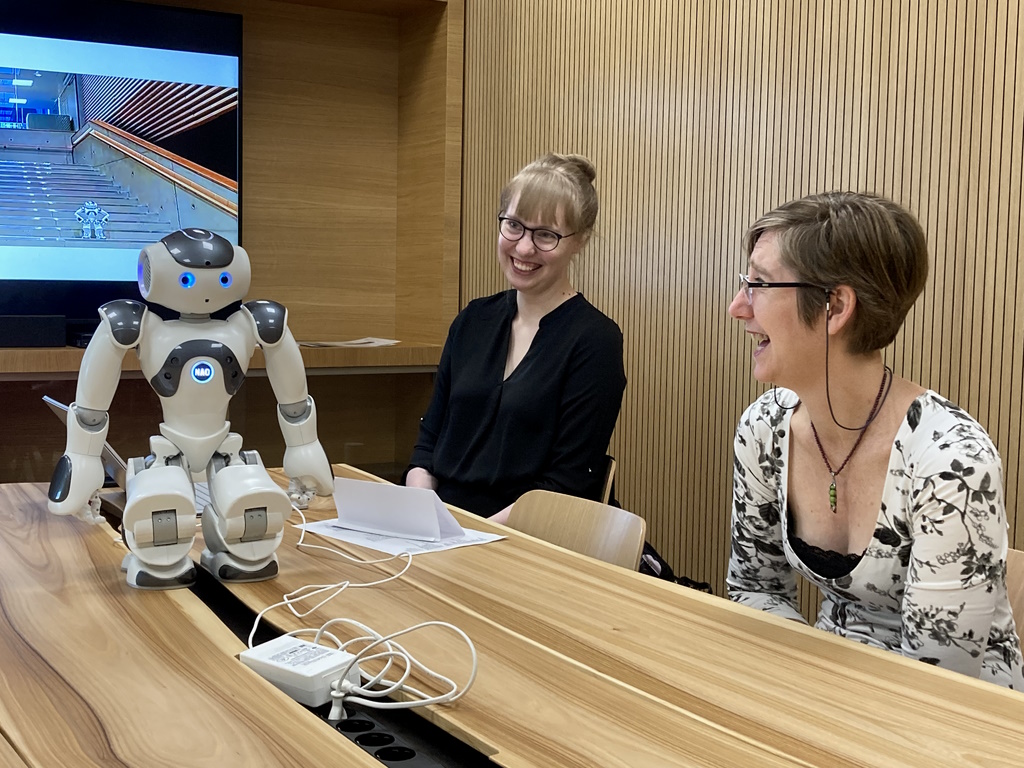 Language learning robot and two people meeting at a table