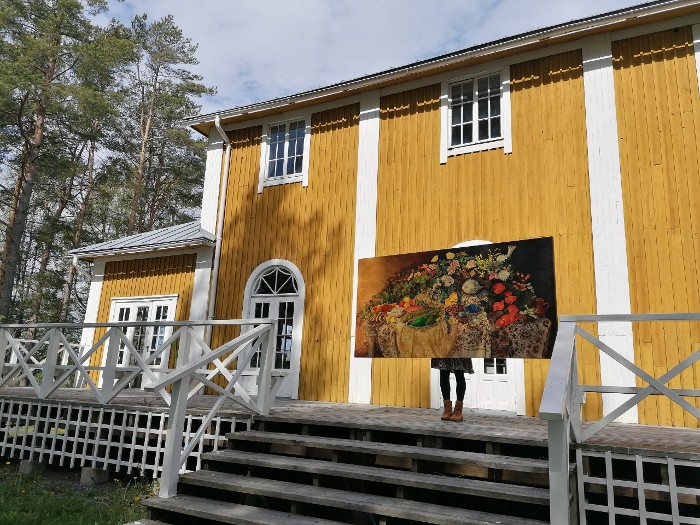 Kuvataiteilija Maria Leppänen esittelee Vanitas-maalaustaan Eurajoella kesäkoti Krikutillin edustalla. Kuva Marjo Heino.