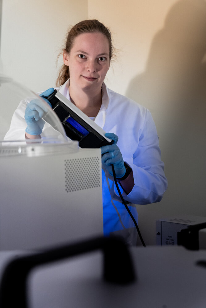 Isabella Pönkkä laboratoriossa uv-valo kädessään.
