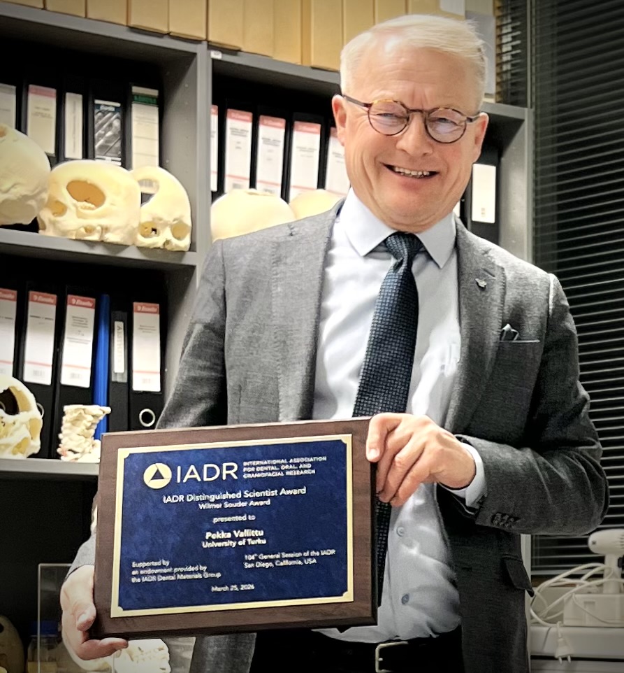 Pekka Vallittu palkintoplaketin kera.