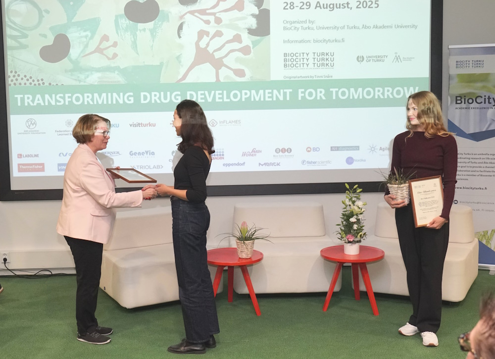 Rector Marjo Kaartinen giving the prizes to the two awardees