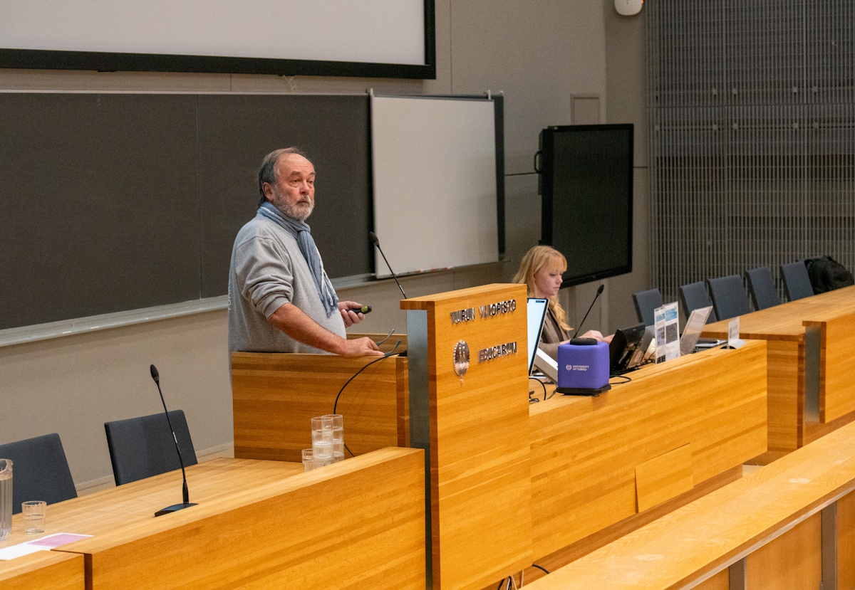 Mies puhuu seminaarissa.