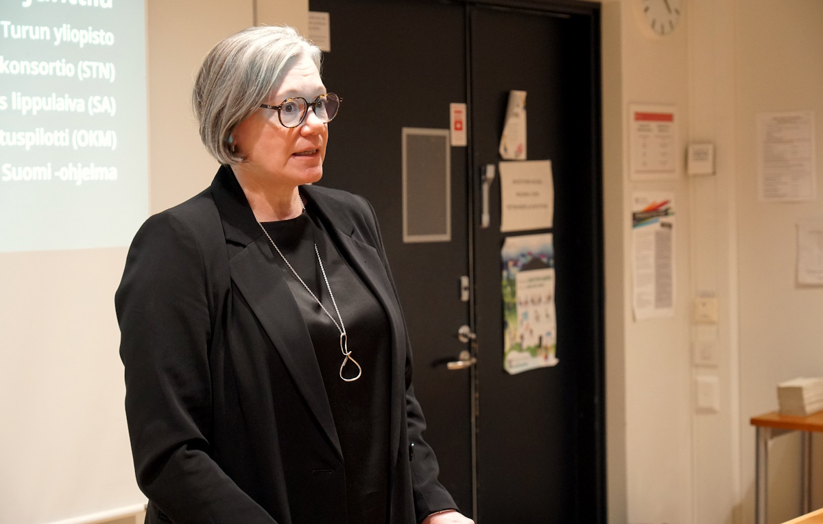 Nainen puhuu tilaisuudessa puhujapöntön takana.