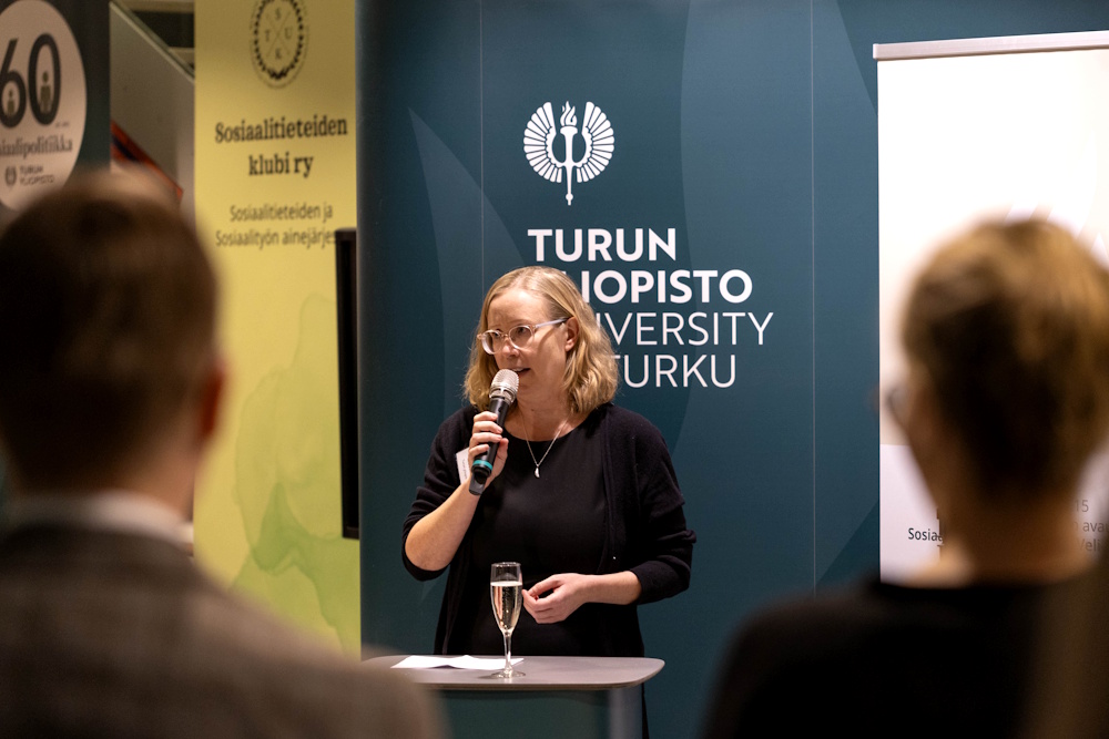 Nainen pitää juhlapuhetta tilaisuudessa