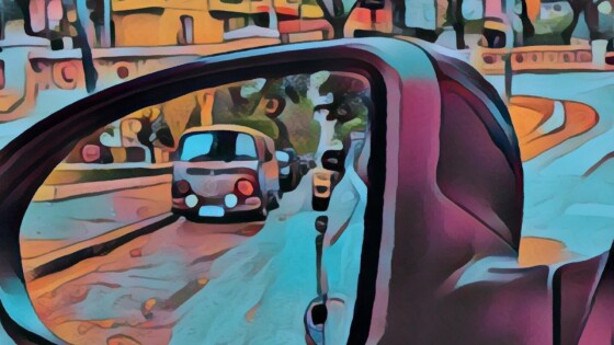 The view reflected in a car’s side mirror