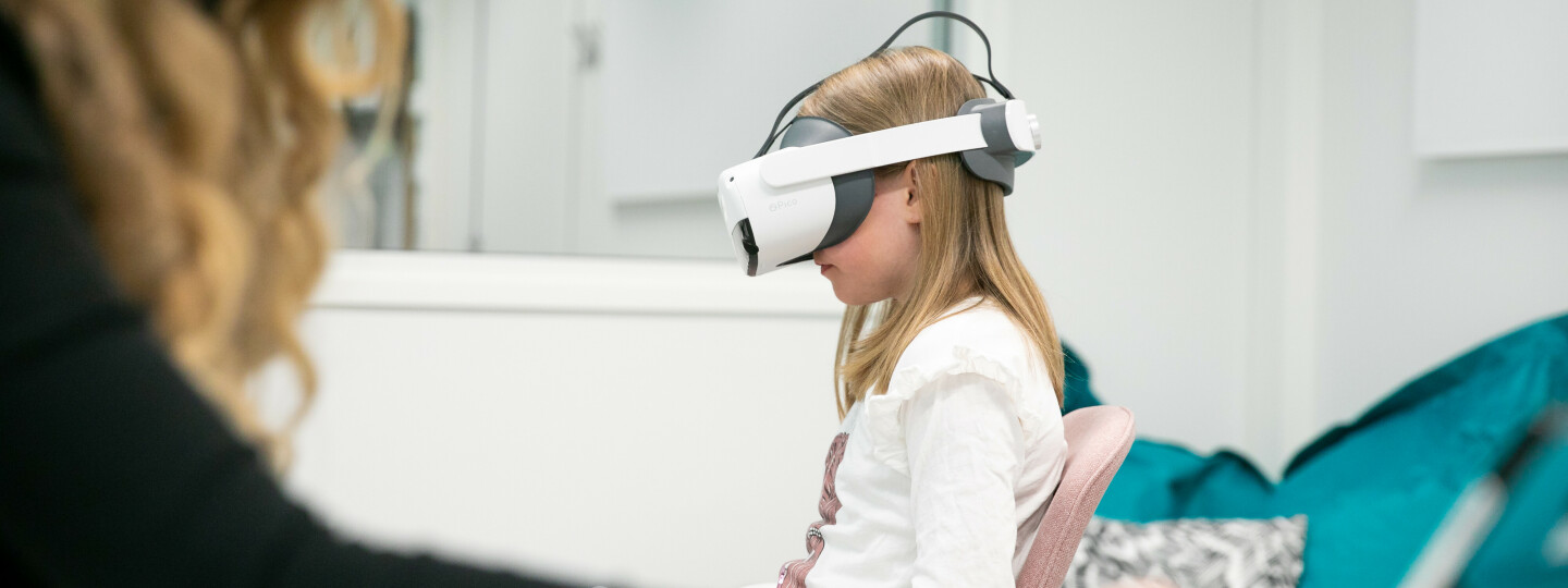 Asiantuntija ja lapsi testaustilanteessa FinnBrain-tutkimuksessa, lapsella on vr-lasit päässä.