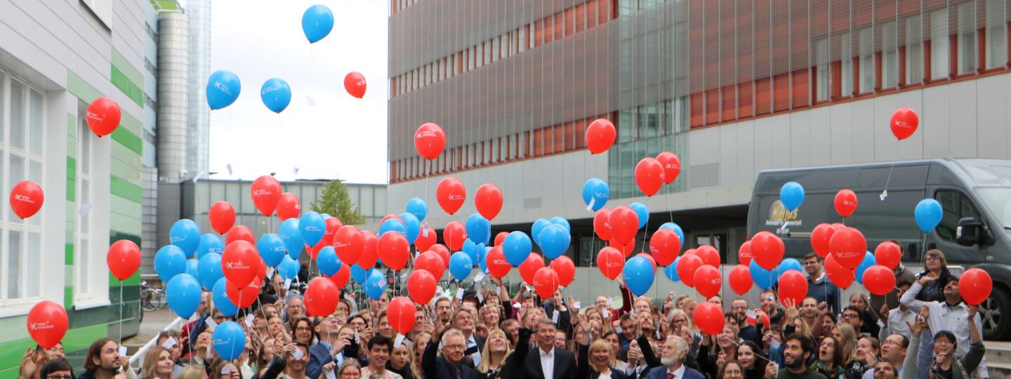 Biotiedekeskuksen väki poseeraa ilmapallojen kanssa