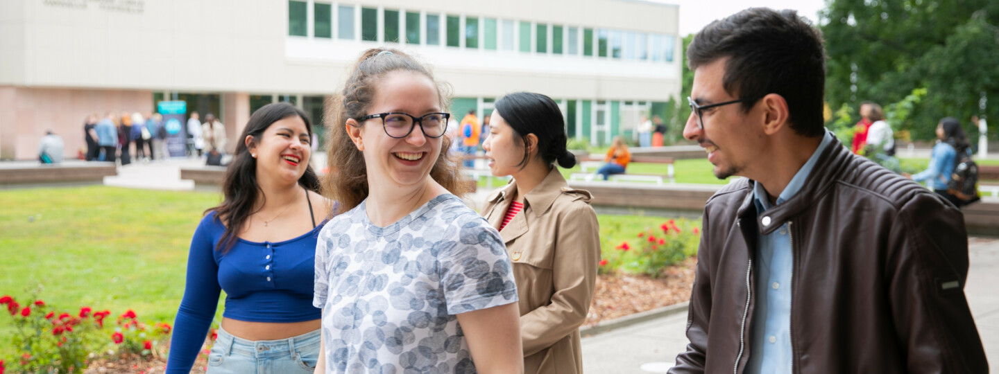 Neljä opiskelijaa juttelee pääaukiolla