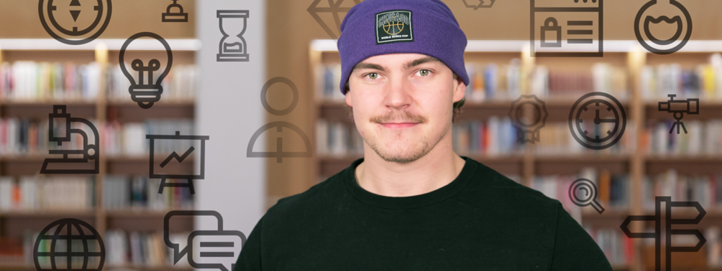 Henkilö katsoo kameraan, taustalla kirjahyllyjä.