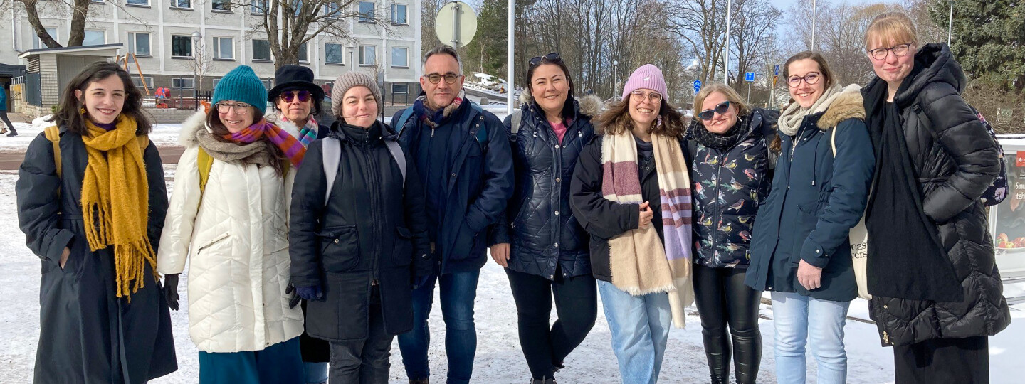 Talvikoulun osallistujia talvisessa maisemassa Turun yliopiston kampuksella.