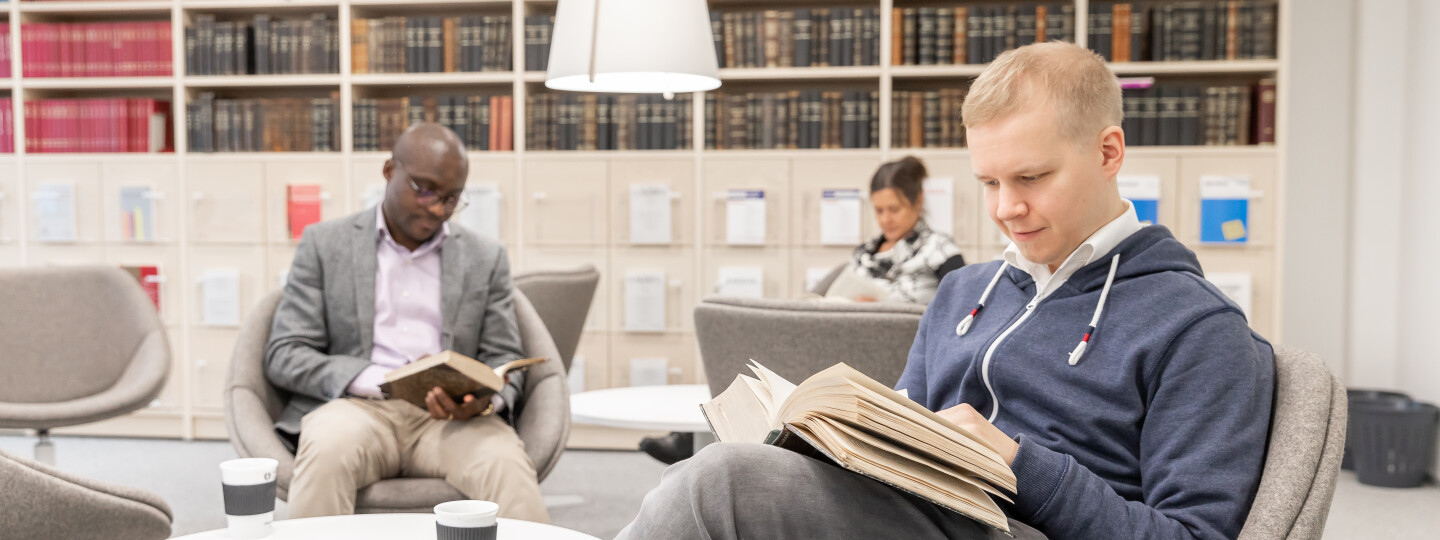 Oikeustieteellisen tiedekunnan tutkijat lukemassa kirjoja