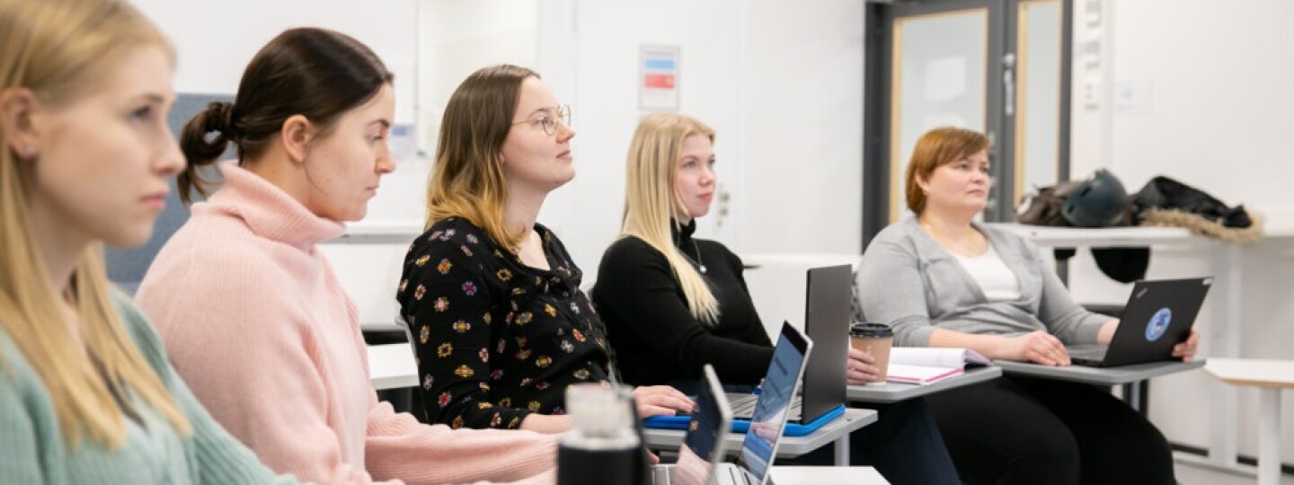 Viisi opiskelijaa seuraamassa opetusta