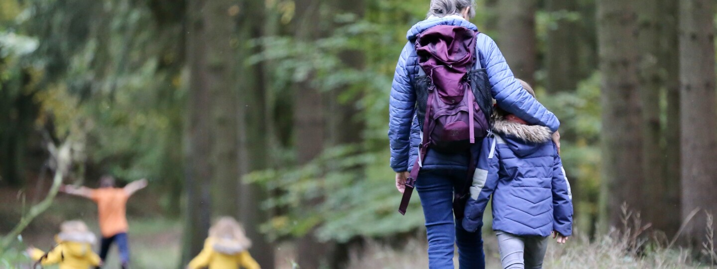 Aikuinen ja lapsia metsätiellä.