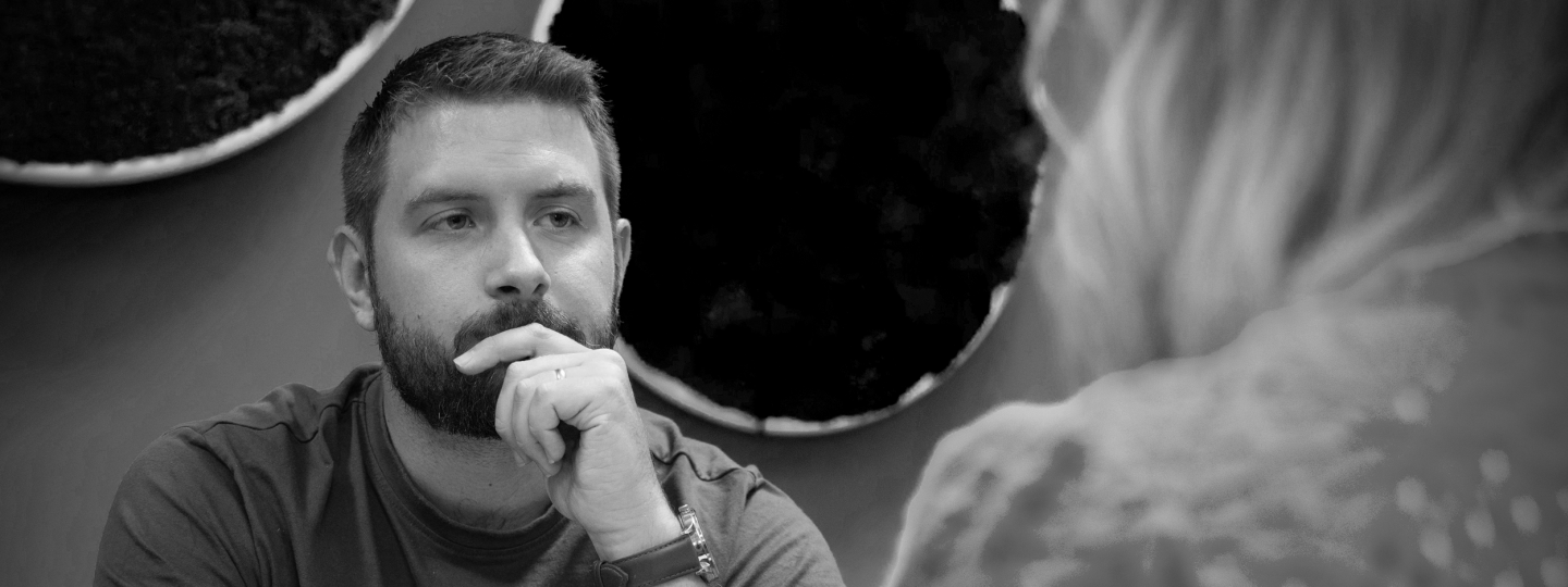 kaksi henkilöä keskustelemassa pöydän ääresssä.