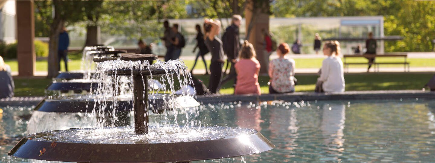 A fountain with people sitting in the background