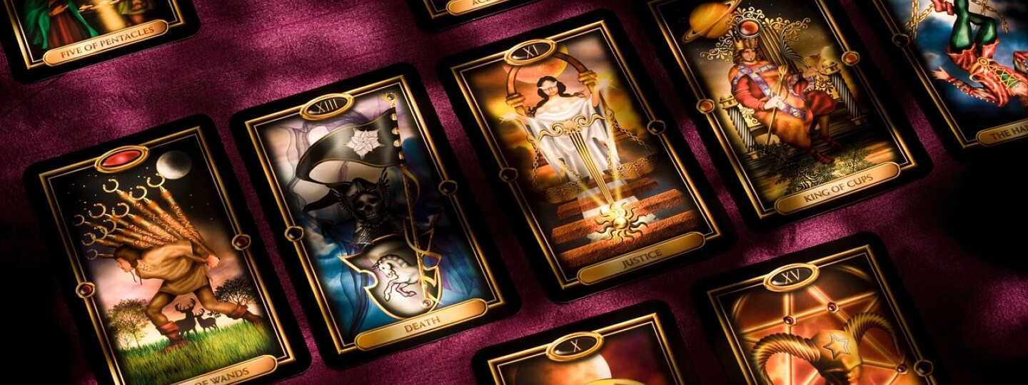 Tarot-kortteja samettisella alustalla salaperäisesti valaistuna