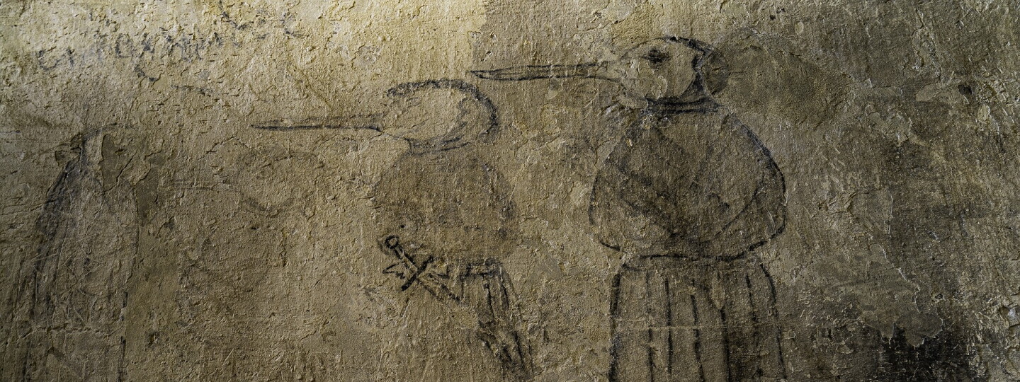 Kuvituskuvassa vanha seinäpiirrustus jossa keskiaikaisia ruttolääkäreitä