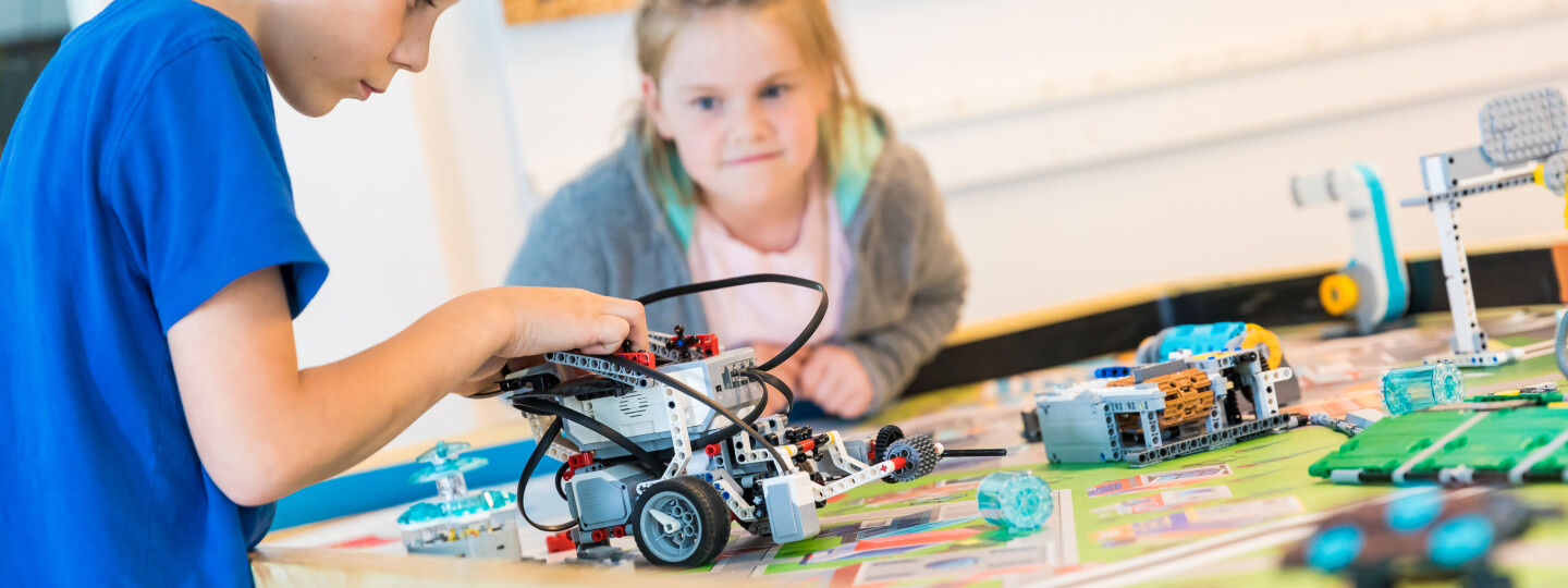 Kaksi lasta testaa itse rakennettuja robotteja.