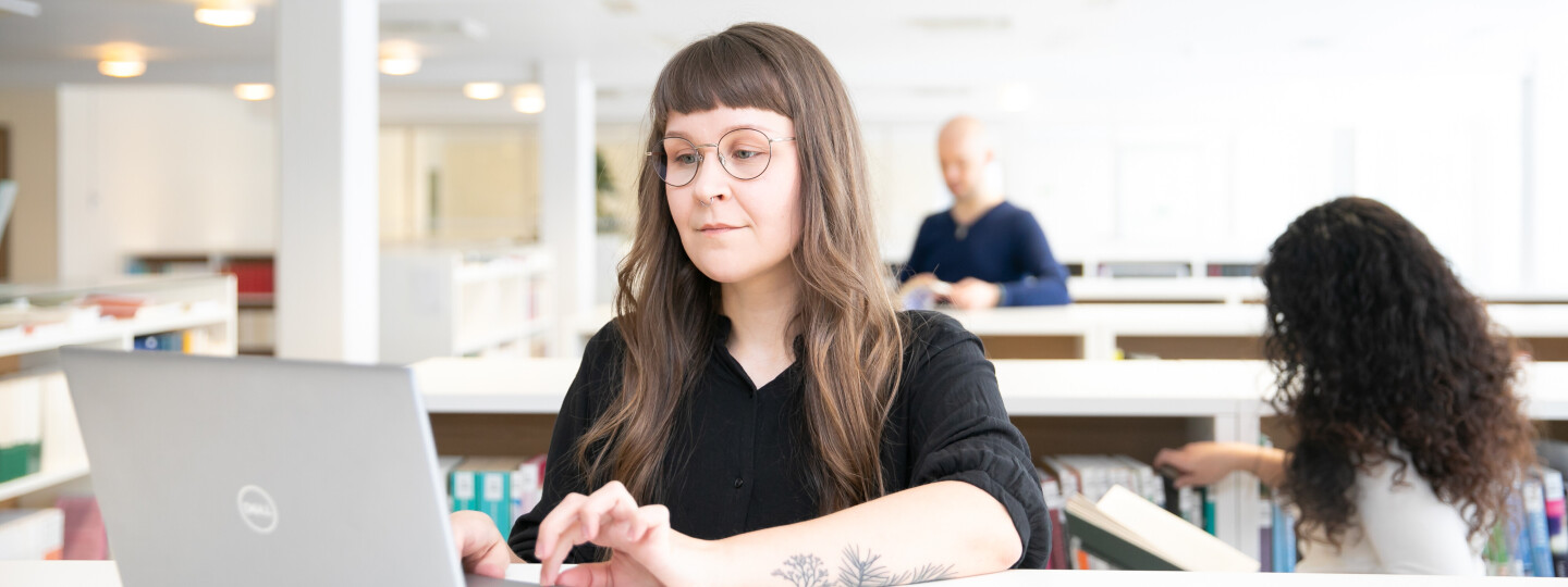 a researcher on a laptop in a library