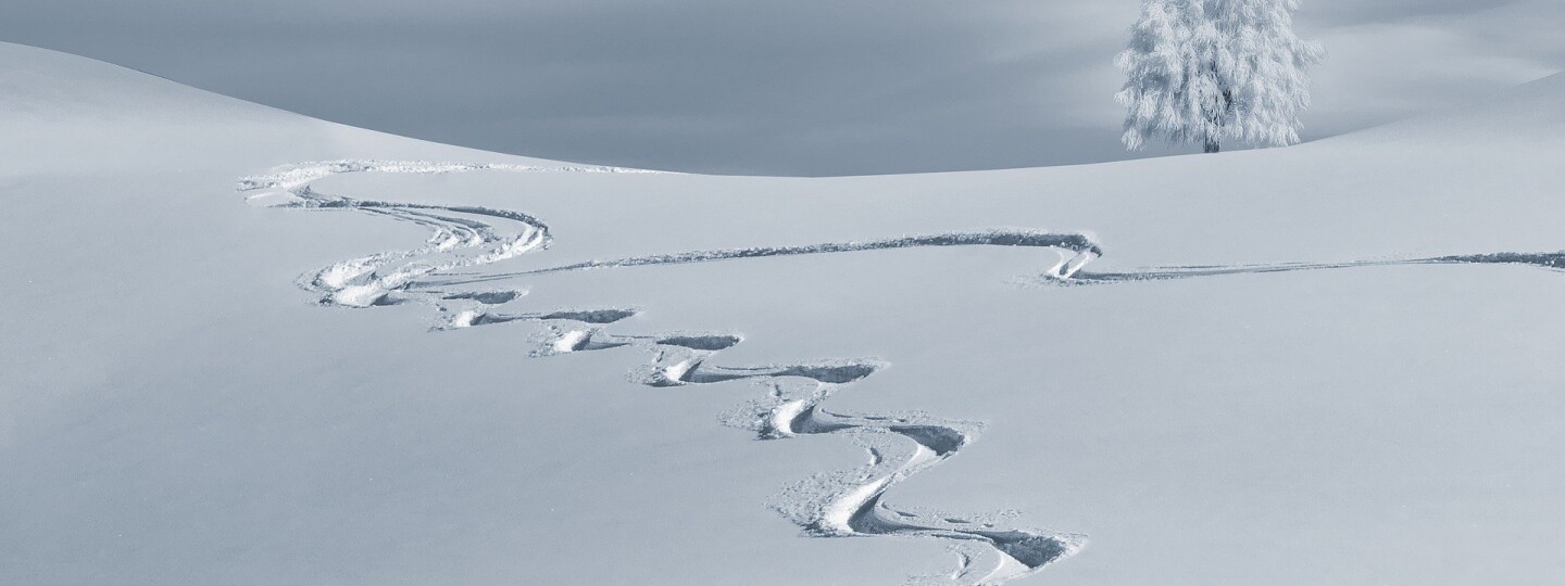 Luminen maisema, jossa kulkee mutkitteleva latu.