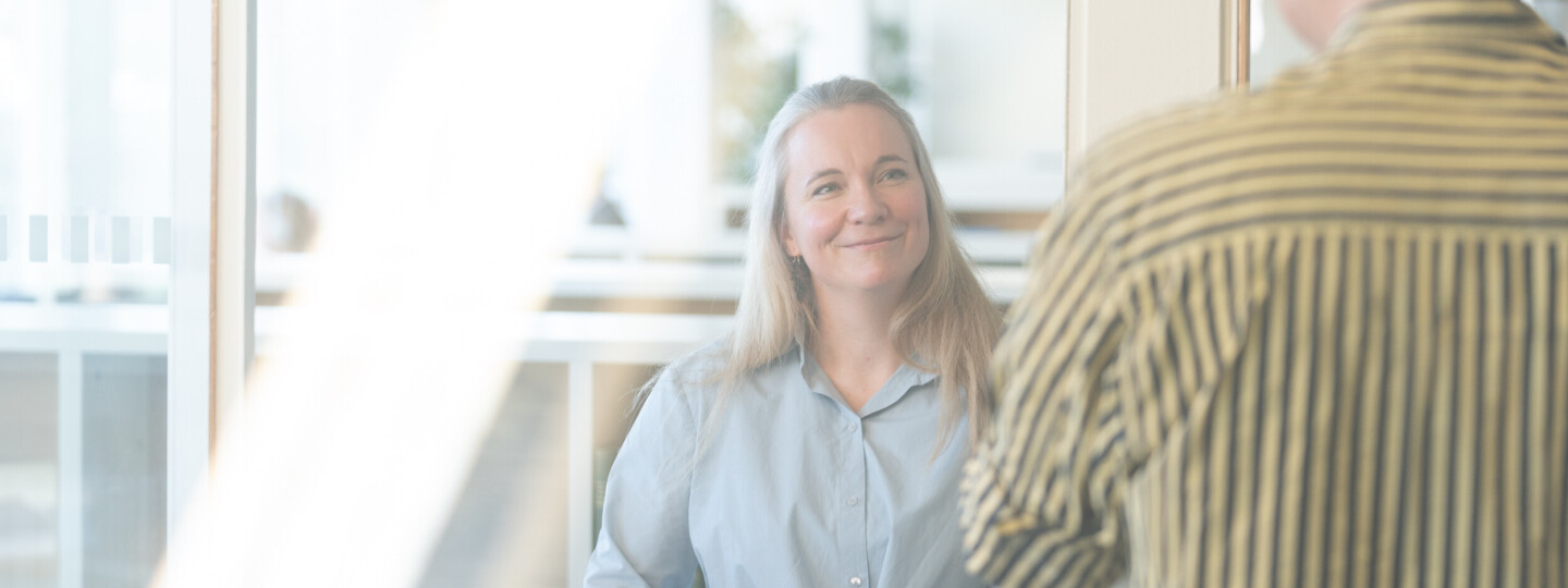 Kaksi henkilöä juttelemassa kirjastossa