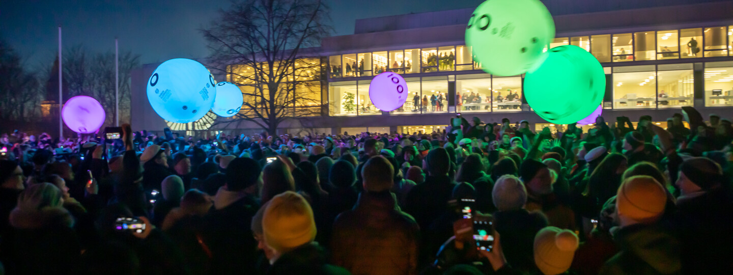 Yleisö heittelee kosketuksesta väriä vaihtavia tsykoottipalloja