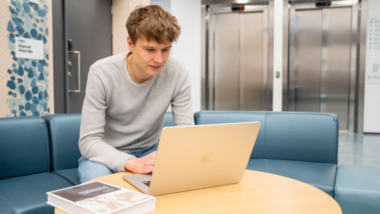 Akseli Ruohola opiskelemassa kannettavalla tietokoneella Medisiinassa