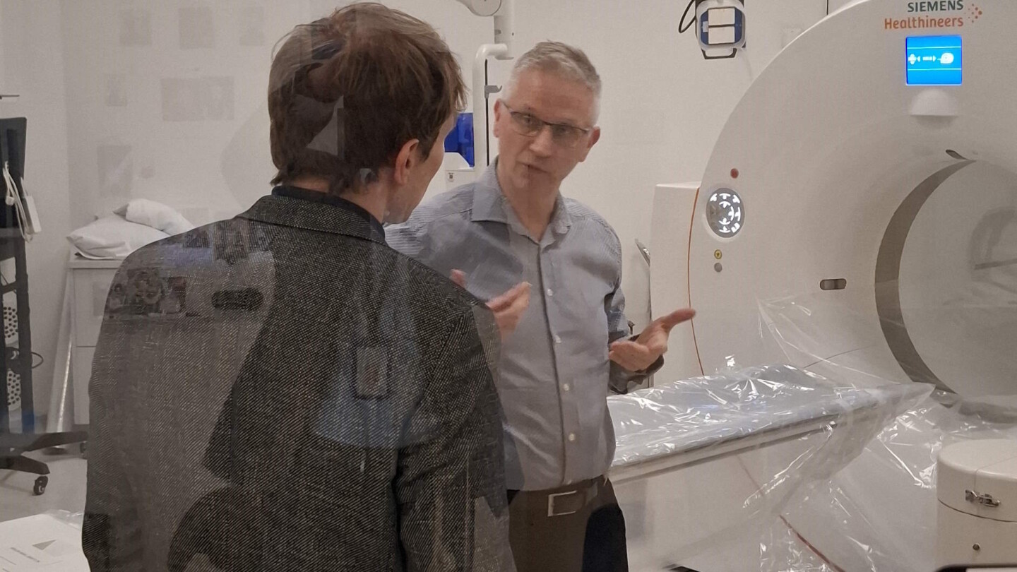 Juhani Knuuti puhumassa Henri Kähöselle PET-laitteen edessä