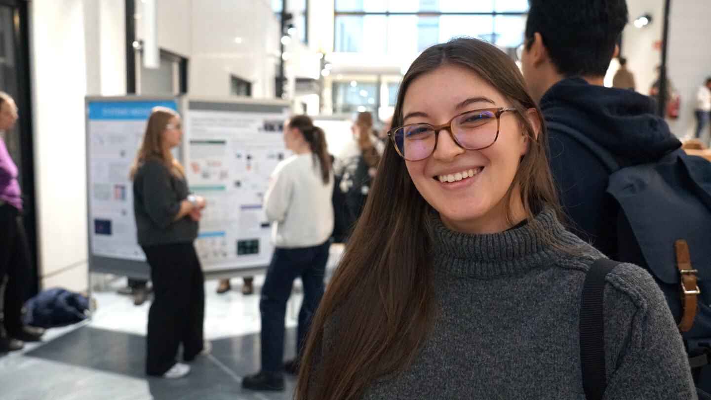 Letícia hymyilemässä postereiden edustalla