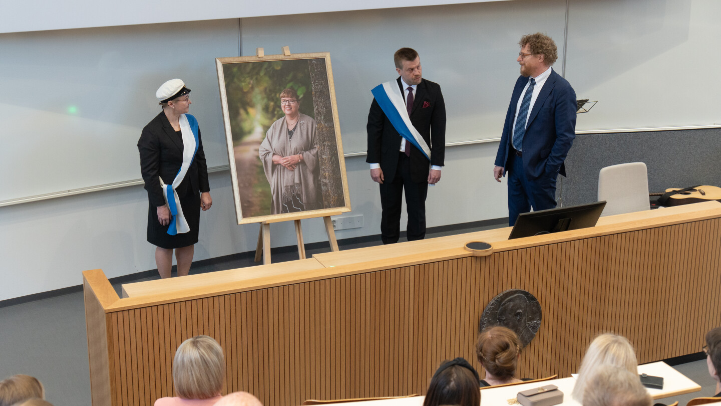 Tapio Salakoski katsomassa muotovalokuvaa