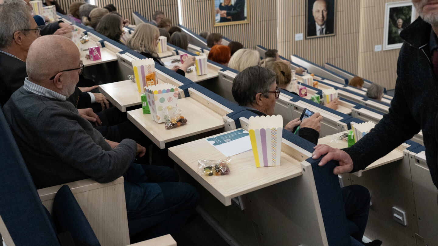 Ihmisiä luentosalissa leffaeväiden kanssa