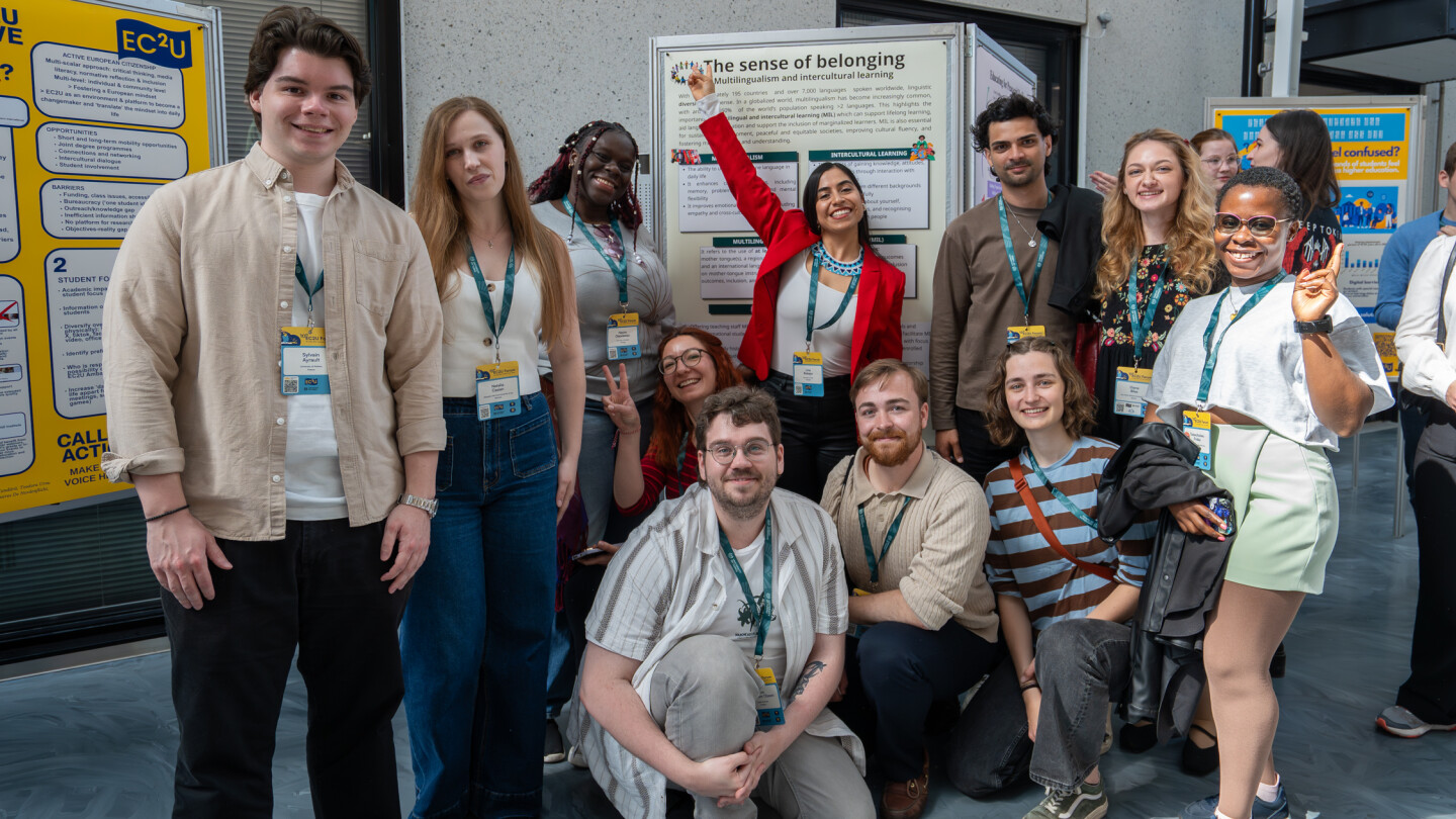 A group of students posing in front of their poster