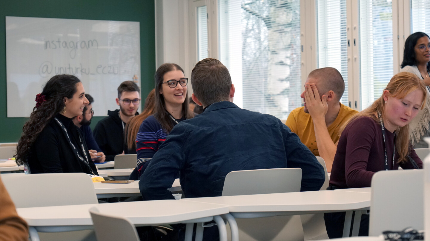 Students working together around tables