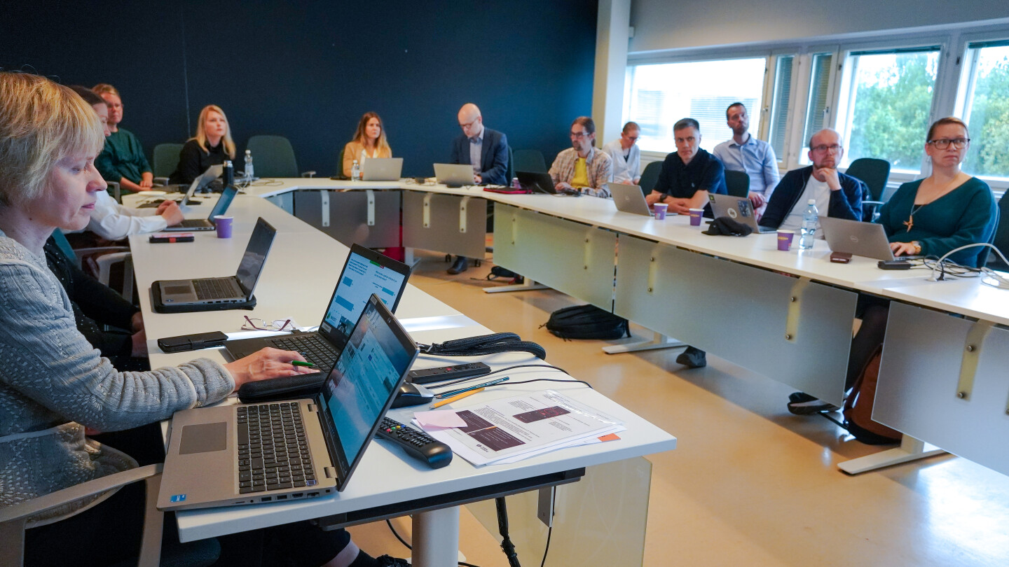 Ihmisiä neuvottelupöydän ääressä.