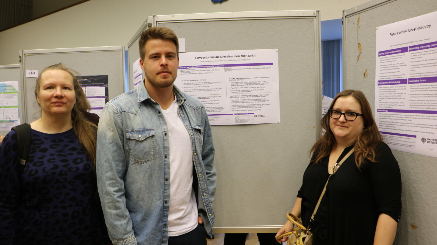 Opiskelijat Terveystoimialan tulevaisuuden skenariot -posterin ympärillä