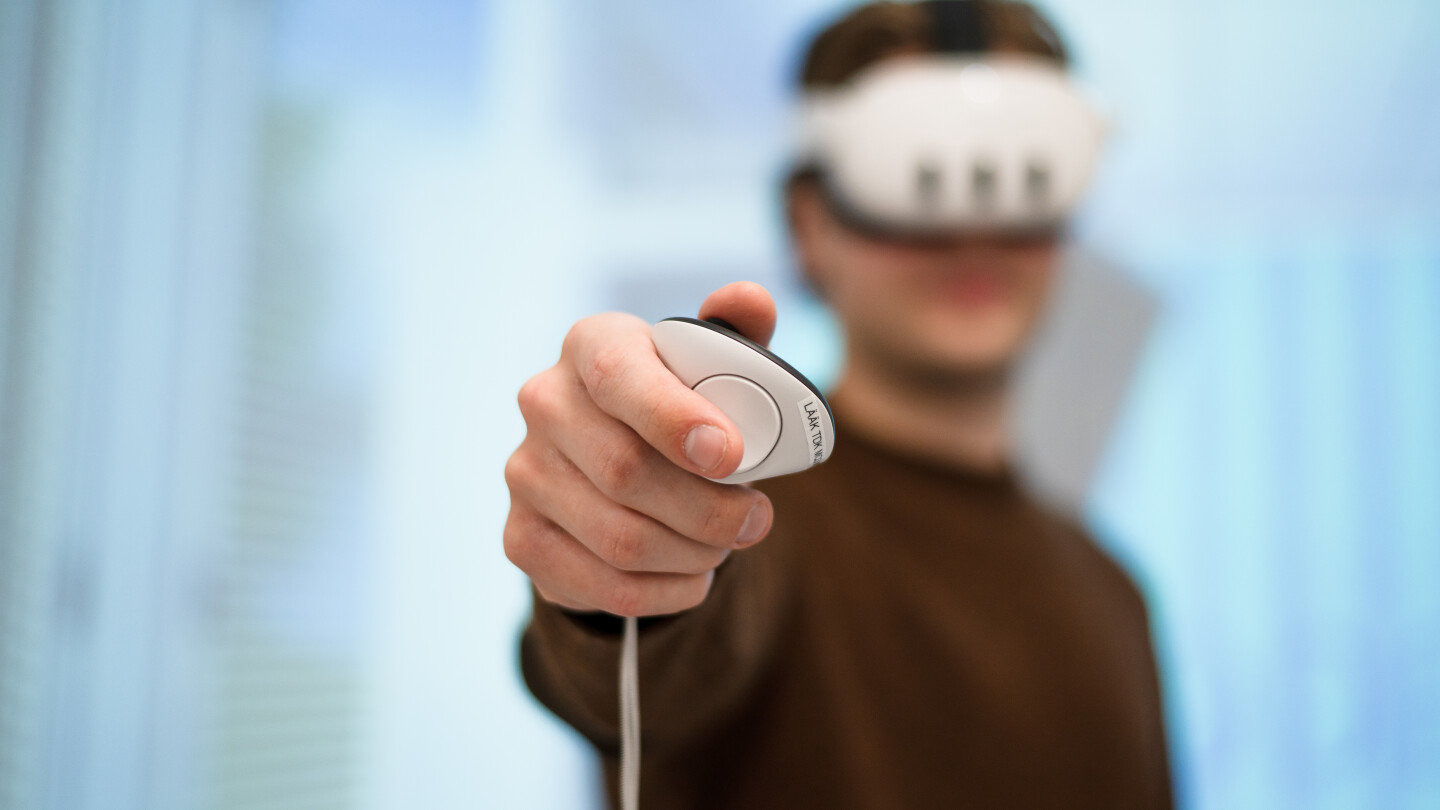Henkilö VR-lasit päässä osoittamassa ohjaimella kameraan