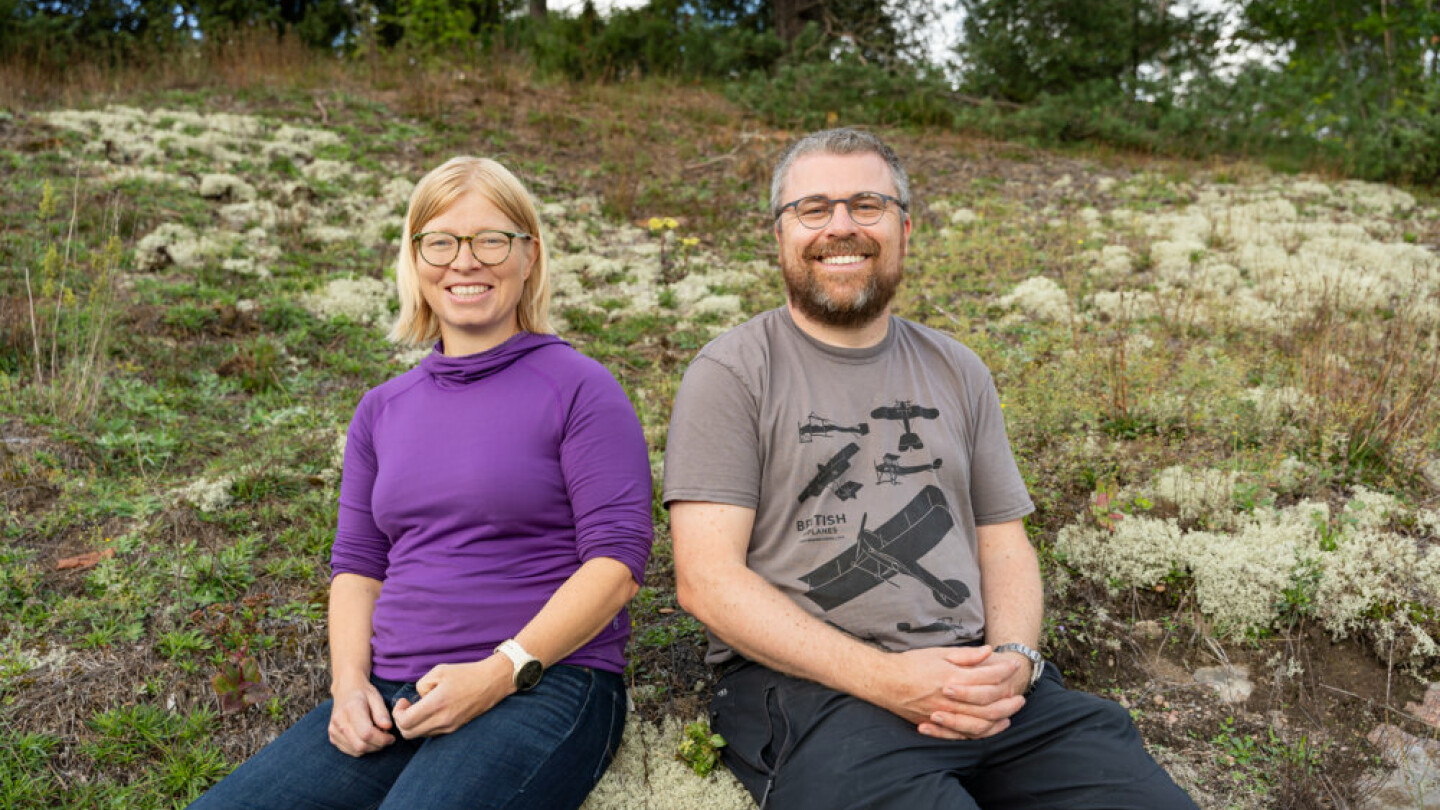 Veronika Laippala and Filip Ginter sitting on a mossy hill.