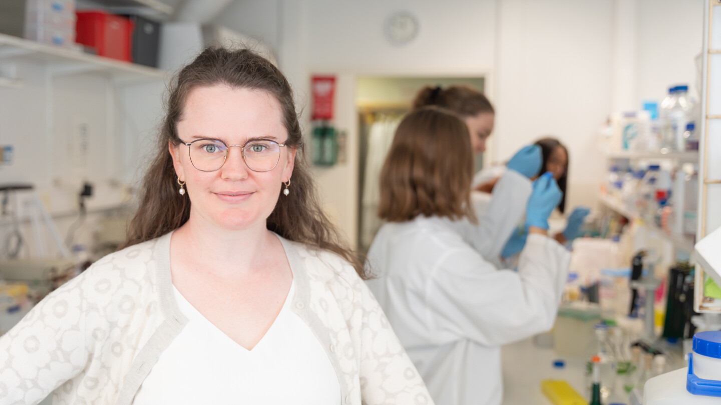 Laura Wey laboratoriossa, taustalla muita ihmisiä.
