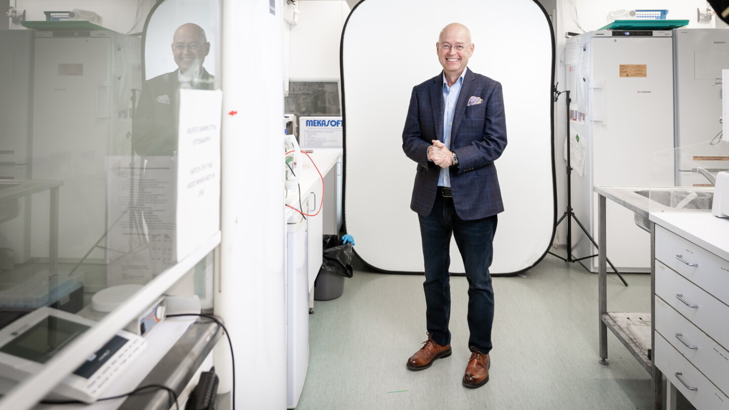 Timo Veromaa seisoo laboratoriossa ja katsoo kameraan.