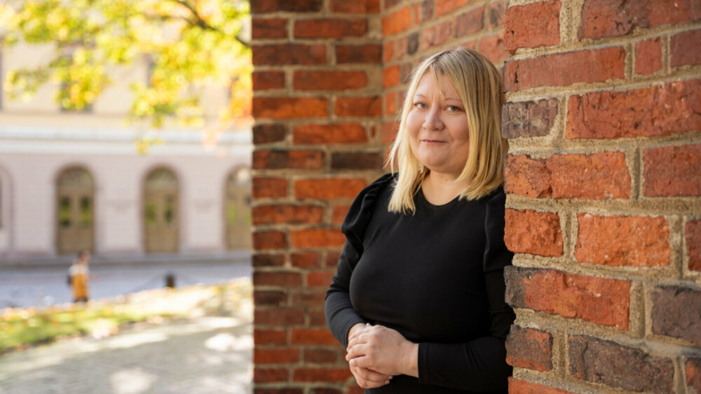 Ulla Moilanen pictured next to a brick wall.