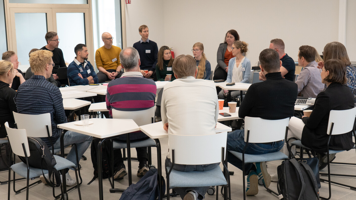 Työpajan osallistujia puhuu ringissä