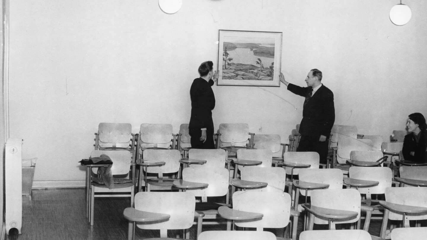 Turun kauppakorkeakoulun toiminta vakiintui aluksi Aurakadulle. Tilojen somistamiseksi saatiin lahjoituksina rehtori Unto Virtasen aloitteesta joukko taideteoksia, joita kuvassa sijoitetaan kolmannen vuosikurssin luokan seinälle helmikuussa 1955.