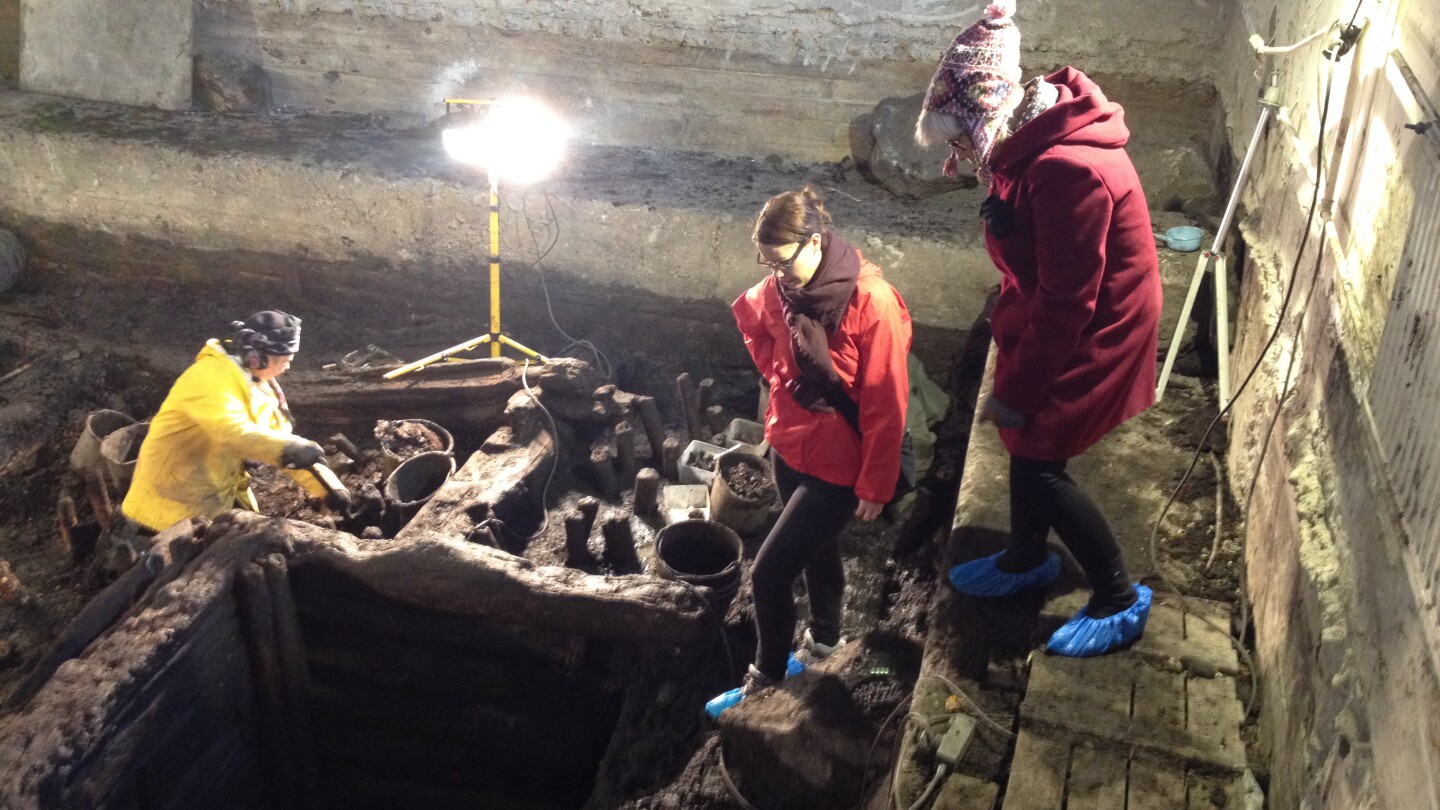 Kolme ihmistä arkeologisilla kaivauksilla.