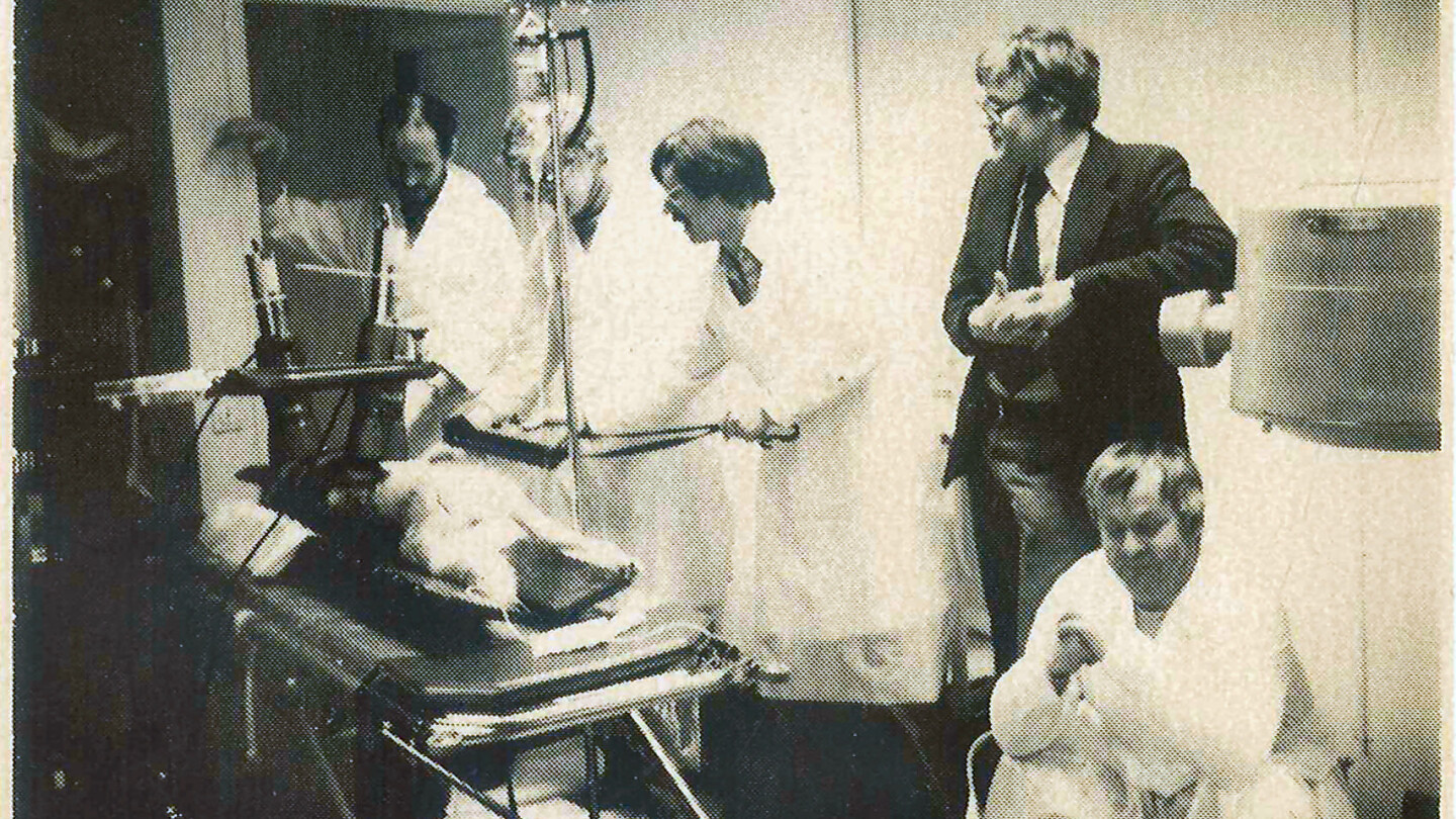 Mustavalkoinen kuva ihmisistä kuvantamislaitteen edessä