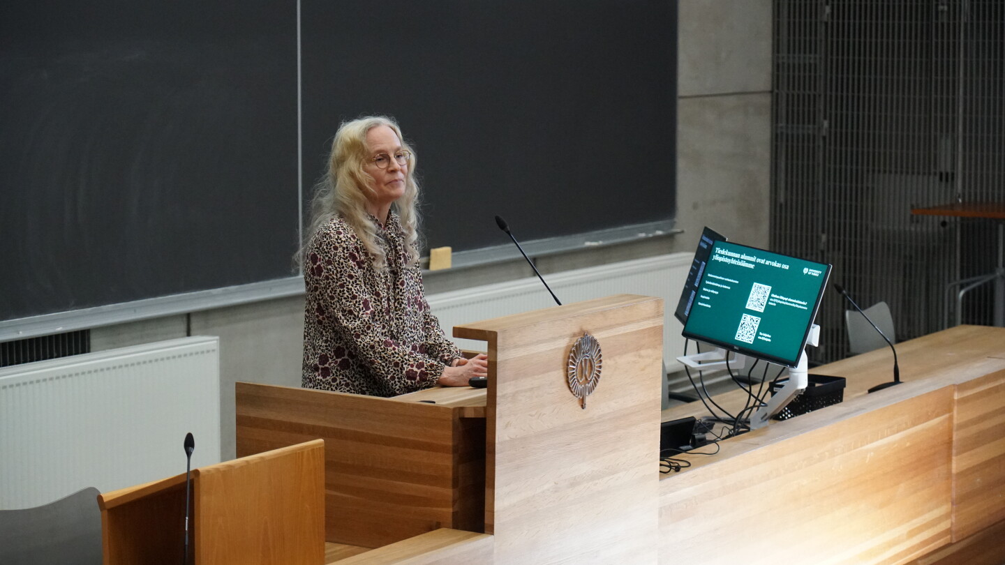 Nainen puhumassa luentosalissa.