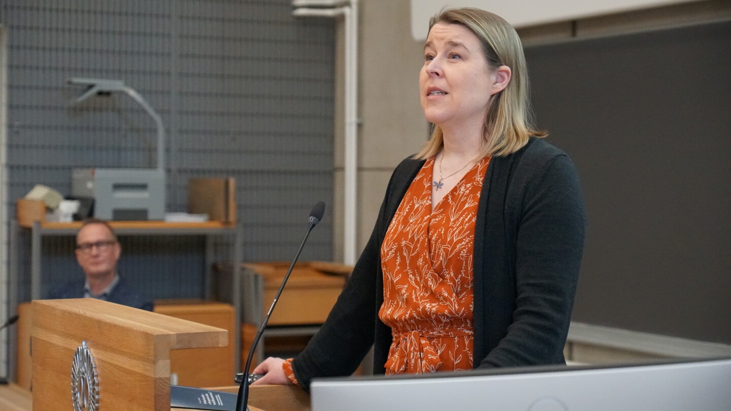 Nainen puhumassa luentosalissa.