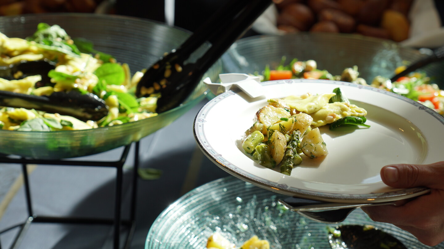 Erilaisia salaatteja tarjolla pöydällä.