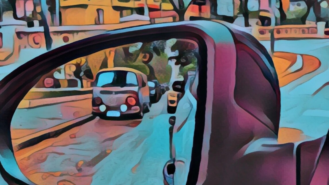 The view reflected in a car’s side mirror